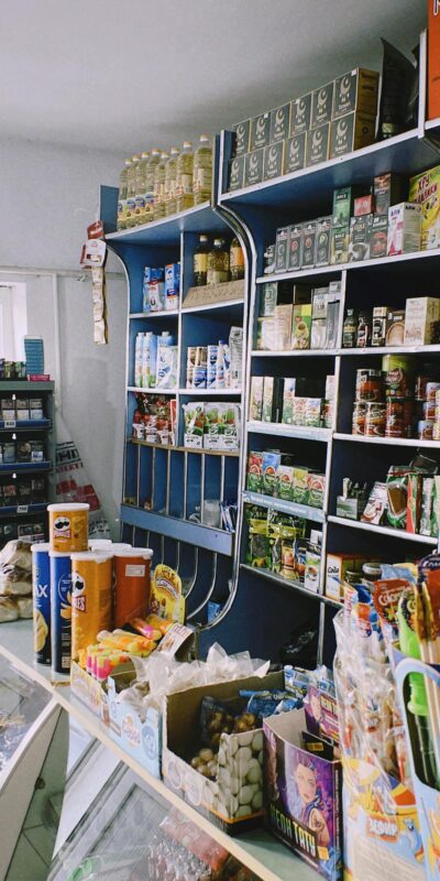 Packed shelves in a Shymkent grocery store with various products on display.
